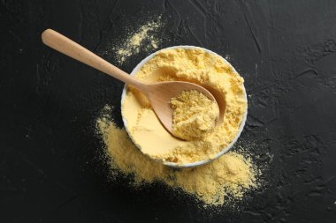 Mısır unu kasede ve kaşık siyah desenli masa, üst manzara