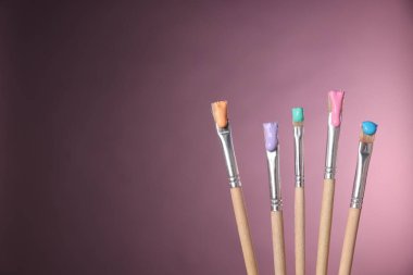 Pembe arka planda renkli fırçalar, yakın plan. Metin için boşluk
