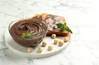 Çikolata, naneli ve fındıklı beyaz mermer masa, yakın plan.