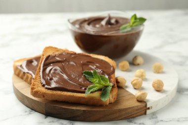 Çikolata, naneli ve fındıklı beyaz mermer masa, yakın plan.