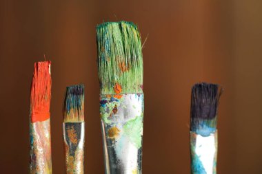 Ahşap arka planda birçok kirli boya fırçası, yakın plan