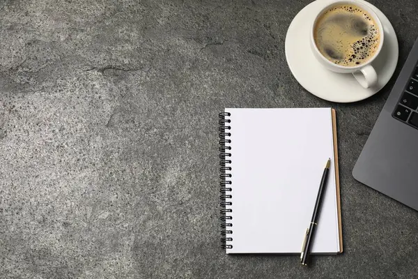 Defter, kalem, kahve ve dizüstü bilgisayar gri masada, düz yerde. Metin için boşluk