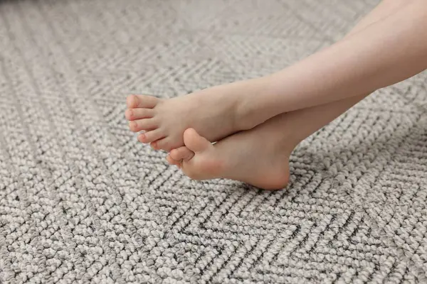 Evdeki gri halıdaki kız, yakın plan.