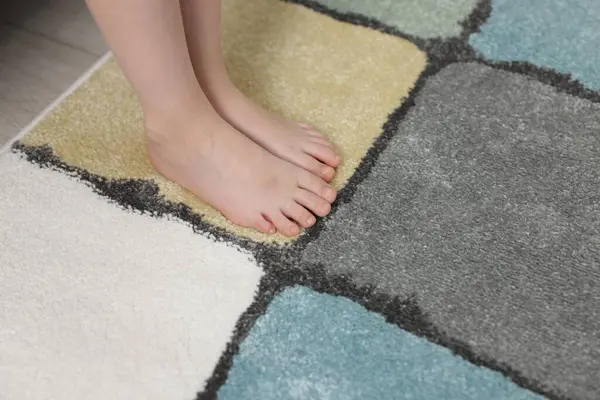 Evdeki yumuşak halıdaki kız, yakın plan.