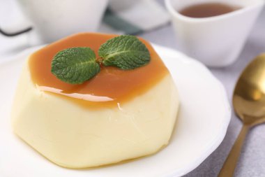 Karamel soslu lezzetli puding ve nane şekeri, yakın plan.