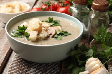 Ekmek arası mantar kremalı çorba, maydanoz ve ahşap masa malzemeleri, yakın plan.