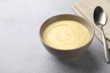 Kasede vanilyalı puding ve açık gri masada kaşık, yakın plan. Metin için boşluk