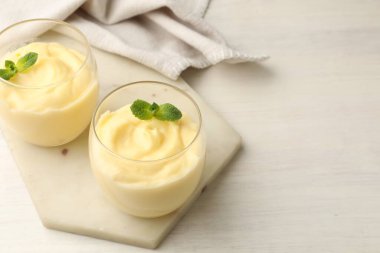 Beyaz ahşap masada naneli vanilyalı puding. Metin için boşluk