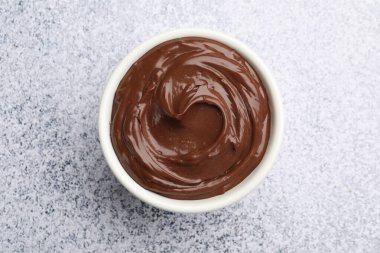 Açık gri desenli masada, kasede nefis çikolatalı puding.