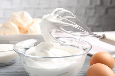 Krem şantili çırpı çırpma ve gri masadaki diğer malzemeler, yakın plan. Kurabiye pişiriyorum.