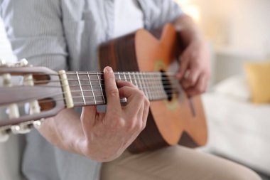 Evde gitar çalan adam, eline odaklan.