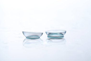 Kontakt lensler ve su damlaları beyaz ayna yüzeyine düşer. Yakın plan.