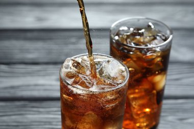 Gri ahşap masada ferahlatıcı kolayı cama boşalt.