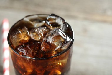 Bulanık ışık arka planında buzlu buzlarla kola tazeleniyor, yakın plan. Metin için boşluk