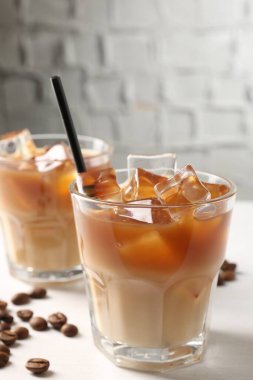 Lezzetli buzlu kahve ve fasulyeler beyaz masada, yakın plan.