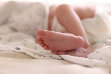 Küçük bebek yatakta uzanıyor, yakın plan.