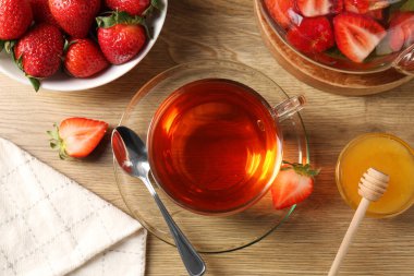 Aromatik meyve çayı, çilekli ve balı ahşap masa, düz uzanmış.