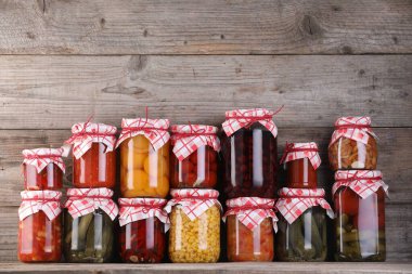 Ahşap masada farklı turşu ürünleri olan bir sürü kavanoz.