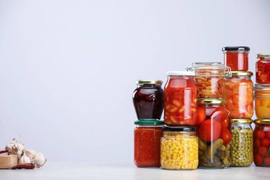 Açık gri arkaplan için farklı turşu ürünleri ve malzemelere sahip pek çok kavanoz, metin için boşluk