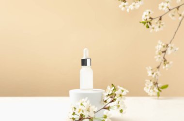 Kozmetik ürünlerin şık sunumu ve bej arka planda güzel çiçekli dallar