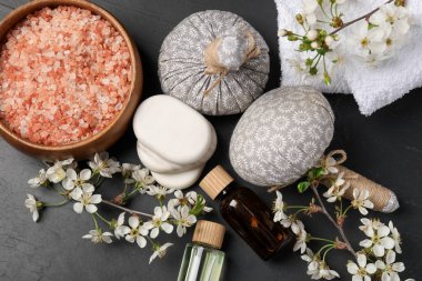 Siyah desenli masa üzerinde kozmetik ürünleri ve güzel çiçeklerle spa kompozisyonu, düz yatıyordu.