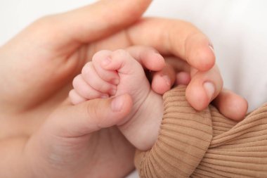 Anne, küçük bebeği evde, yatağında, yakın plan.