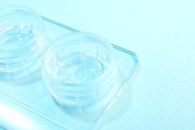 Açık mavi arkaplanda kontak lensli dosya, yakın plan