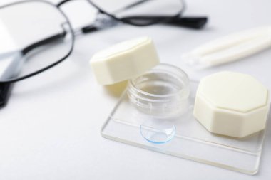 Beyaz arkaplanda kontak lensli ve gözlüklü dosya, yakın plan