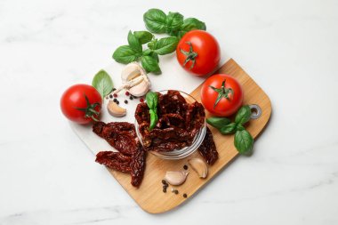 Lezzetli güneşte kurutulmuş domatesler, taze sebzeler ve baharatlar beyaz mermer masa, üst manzara