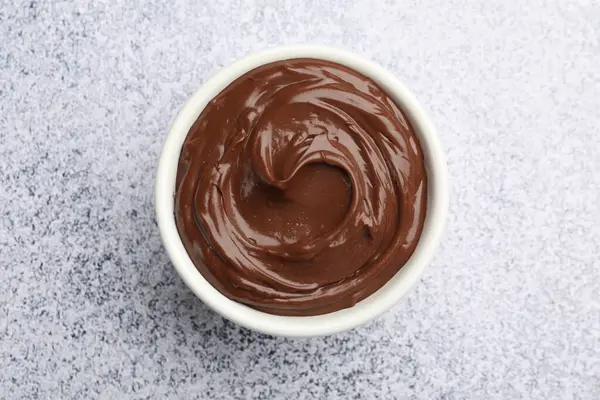 Açık gri desenli masada, kasede nefis çikolatalı puding.