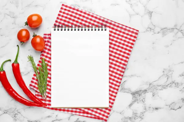 Boş yemek tarifi kitabı ve beyaz mermer masa üzerindeki ürünler. Tasarım için model