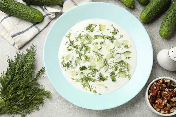 Salatalık çorbası, dereotlu ve fındıklı gri desenli masa, düz uzanmış.