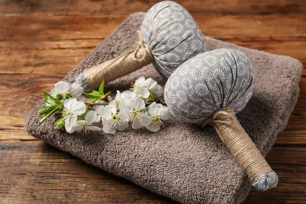 Bitki torbaları, havlu ve dal, ahşap masada güzel çiçekler, yakın plan.