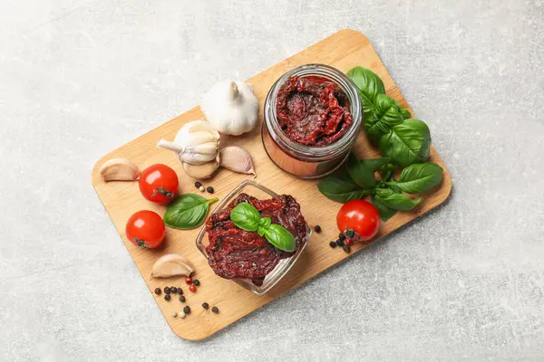Lezzetli güneşte kurutulmuş domatesler, taze sebzeler, fesleğen ve sarımsak açık gri masa, üst manzara