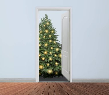 Kapının önünde şenlik ışıkları olan güzel bir Noel ağacı. Tatil sezonu