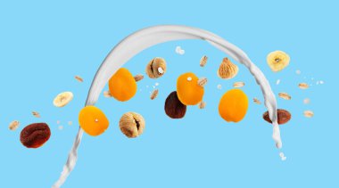 Süt sıçraması, yulaf ezmesi ve açık mavi arka planda kurutulmuş meyve. Pankart tasarımı