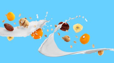 Süt sıçraması, yulaf ezmesi ve açık mavi arka planda kurutulmuş meyve. Pankart tasarımı