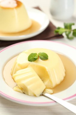 Karamel soslu lezzetli puding ve beyaz masada servis edilen nane şekeri.