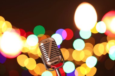 Karanlık arka planda bulanık ışıkları olan klasik mikrofon, mesaj için yer. Müzik ekipmanları