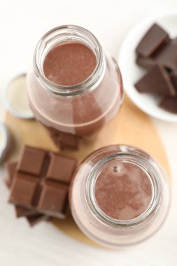 Lezzetli çikolatalı süt ve parçalar beyaz masada, düz yatıyordu.