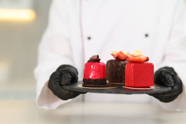 Mutfaktaki beyaz masada lezzetli tatlıları olan şekerci, yakın plan.