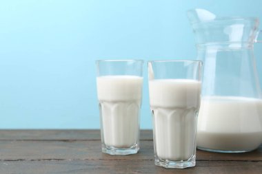 Tahta masada açık mavi arka plana karşı taze süt.