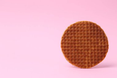 Pembe arka planda lezzetli yuvarlak bir waffle. Metin için boşluk