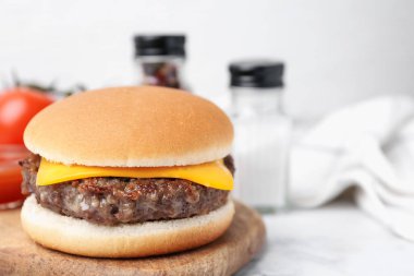 Beyaz mermer masada leziz bir çizburger, yakın plan. Metin için boşluk