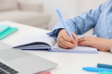 Küçük kız ev ödevlerini içeride yapıyor, yakın plan.