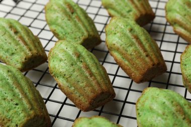 Lezzetli Matcha Madeleine kekleri beyaz masada, yakın plan.