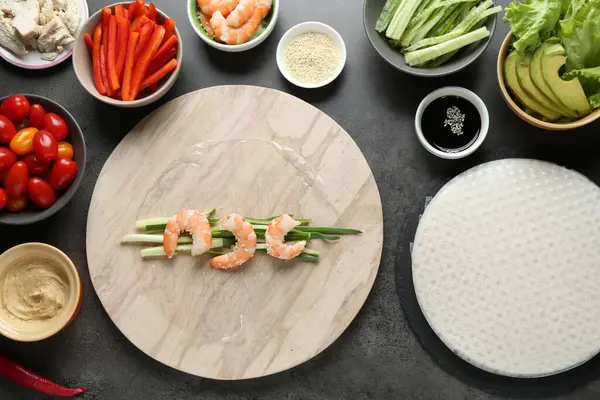 Pilav kağıtları ve farklı malzemeler koyu gri masada, düz yerde.