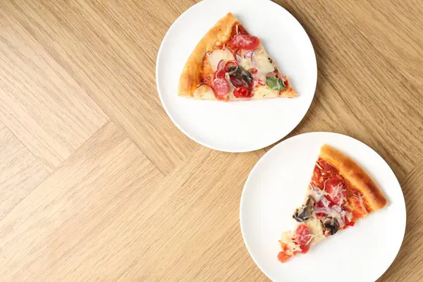 Tahta masada servis edilen ince tütsülenmiş sosisli lezzetli pizza dilimleri. Metin için boşluk