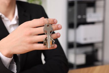 Evin anahtarı içeride olan bir emlakçı, yakın plan. Metin için boşluk
