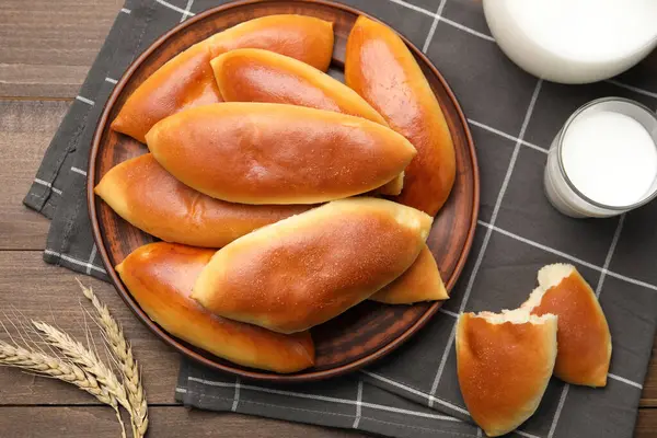 Lezzetli fırında köfteler, süt ve çivili çiviler ahşap masada, düz yerde.